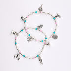 Two beaded bracelets featuring silver-toned charms including a skull, spider, bat, skeleton, and spiderweb. The bracelets are constructed with small white, pink, and turquoise beads interspersed with metallic silver spacer beads.