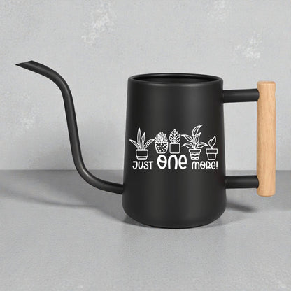Black watering can with wooden handle and plant designs on a gray background