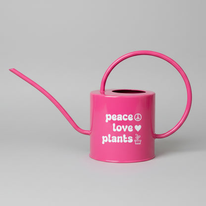 Pink watering can with Peace love plants saying on the side