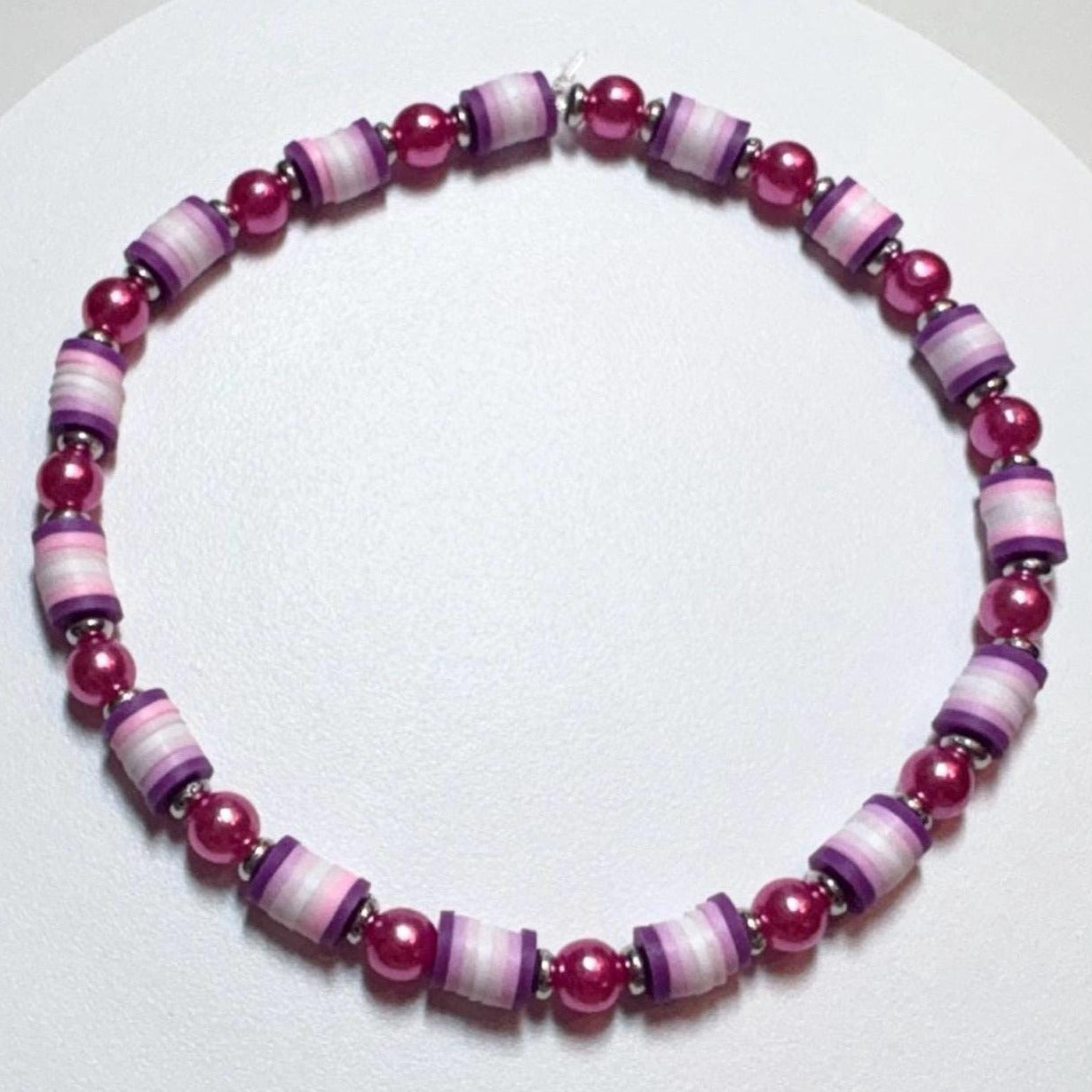 Bracelet with pink and purple beads on a white background