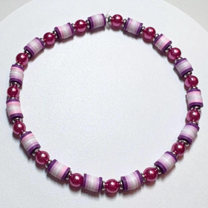 Bracelet with pink and purple beads on a white background