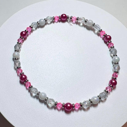Beaded bracelet with pink and white beads on a white background