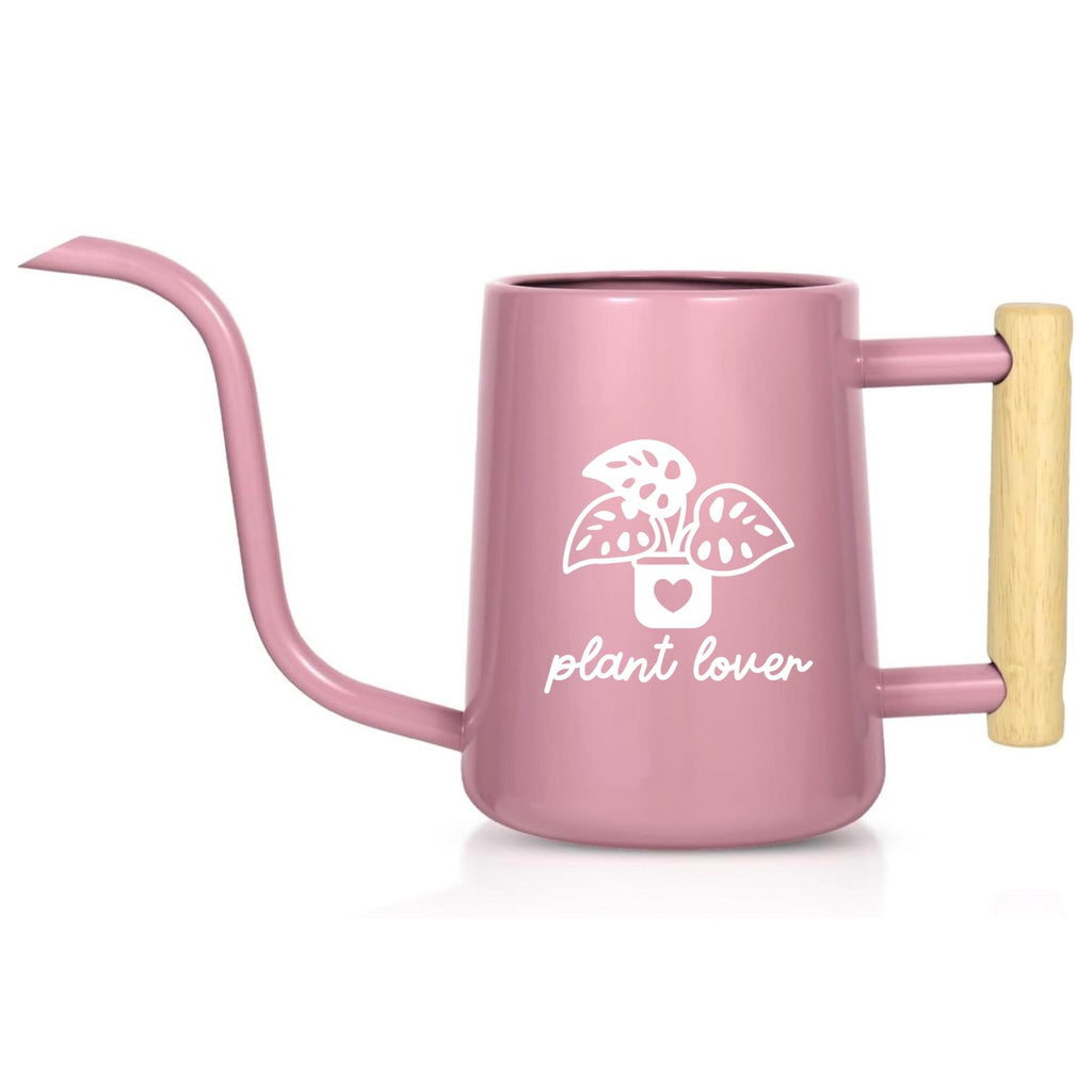 A pink watering can with a long, slender spout and a wooden handle. The can features a white graphic of a plant in a pot with the words "plant lover" below it. The watering can is designed for indoor plant care.